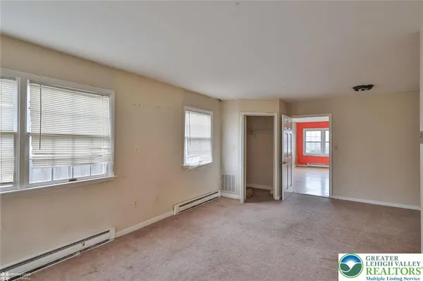 a view of an empty room with a window and a ceiling fan