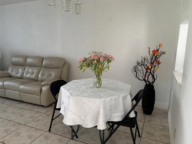 a living room with furniture a dining table and a chandelier