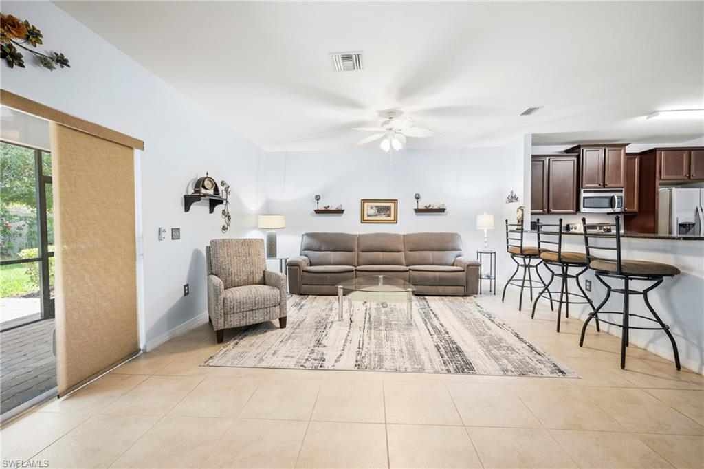 3916 Cherrybrook Loop Fort Myers, FL 33966 - Photo 6 of 31 Expansive open-concept living area featuring large format tile flooring and a ceiling fan