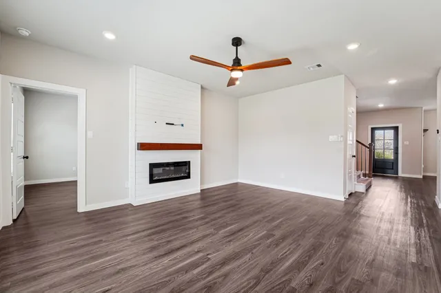 a view of empty room with wooden floor ceiling fan and window
