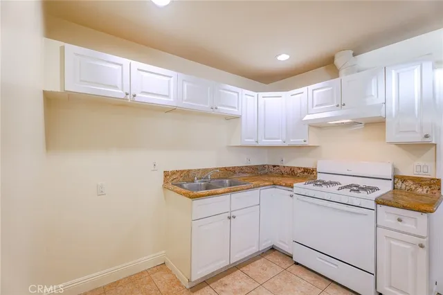 a kitchen with granite countertop white cabinets and white appliances