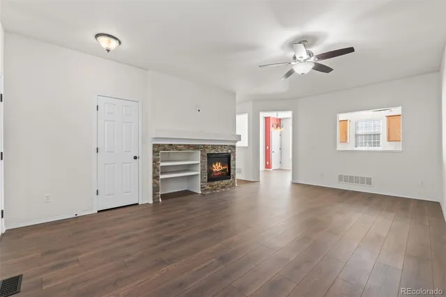 a view of empty room with wooden floor and fireplace