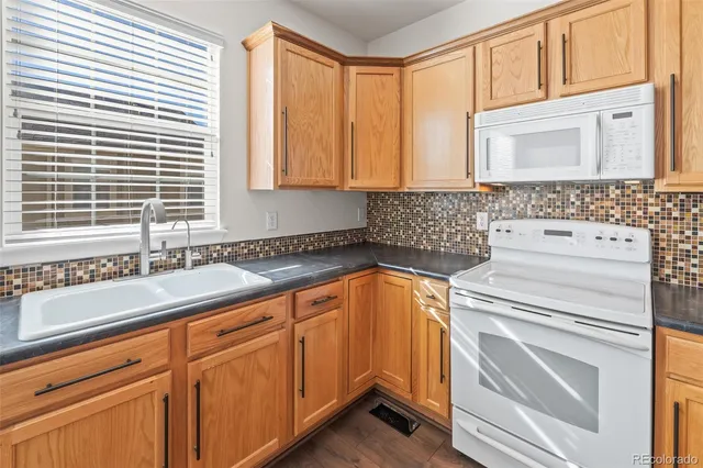 a kitchen with granite countertop a sink and a washer dryer