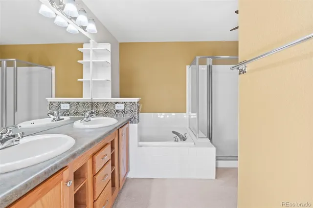 a bathroom with a sink double vanity granite tub shower and a mirror