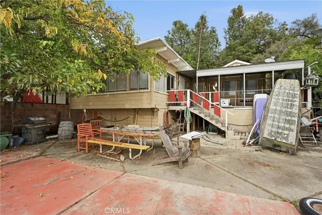 a view of a chairs and table in the back yard of the house