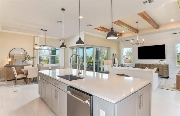 a kitchen with a stove a sink and a flat screen tv