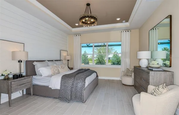 a bedroom with a large bed and a chandelier