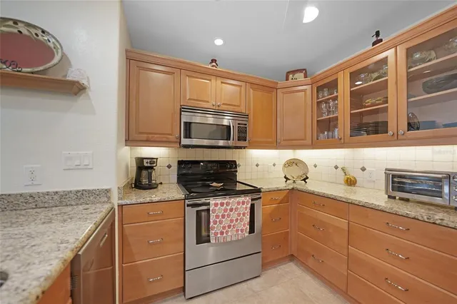 a kitchen with stainless steel appliances granite countertop a stove and cabinets