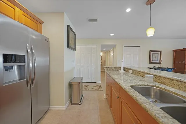 a kitchen with stainless steel appliances granite countertop a sink and a refrigerator