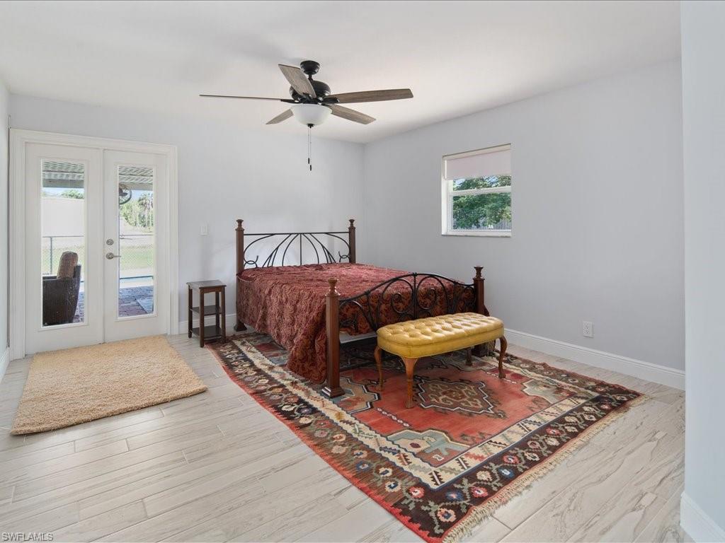 520 Soll Street Naples, FL 34109 - Photo 11 of 31 a bedroom with a bed and a chandelier