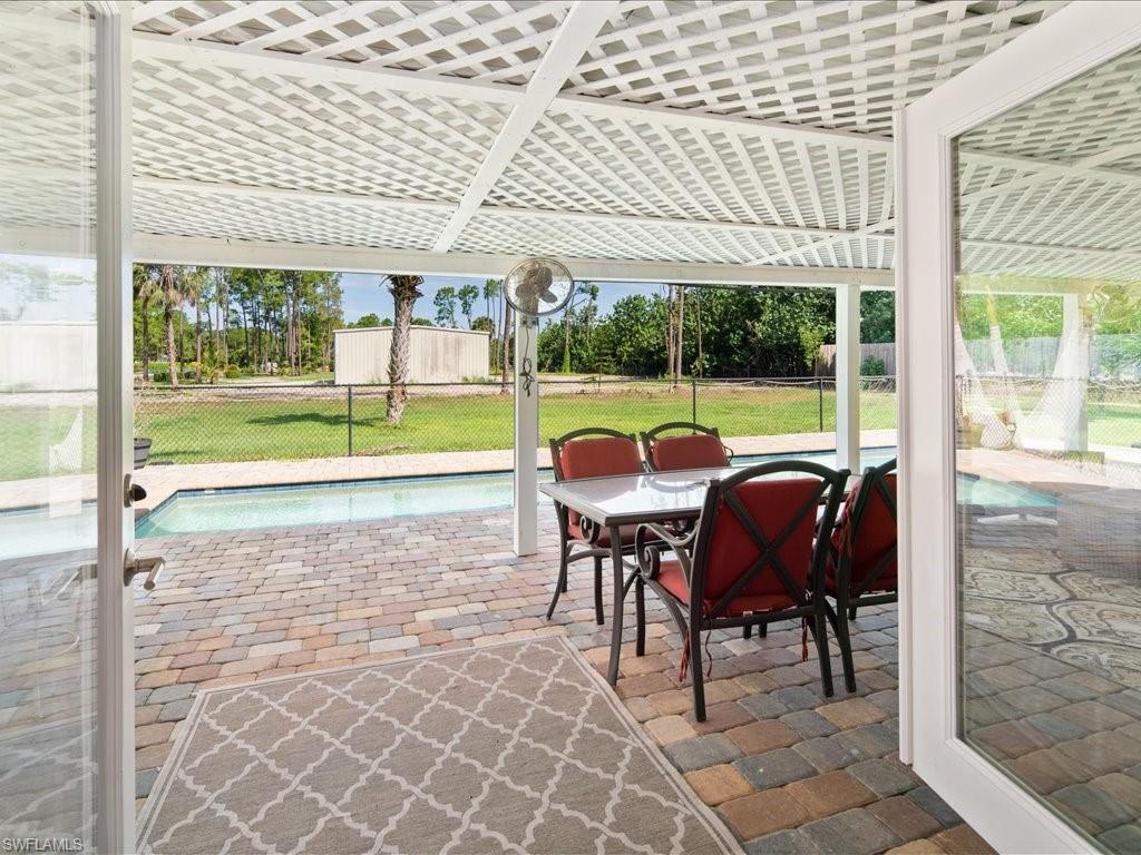 520 Soll Street Naples, FL 34109 - Photo 26 of 31 a view of a patio with table and chairs potted plants with floor to ceiling windows