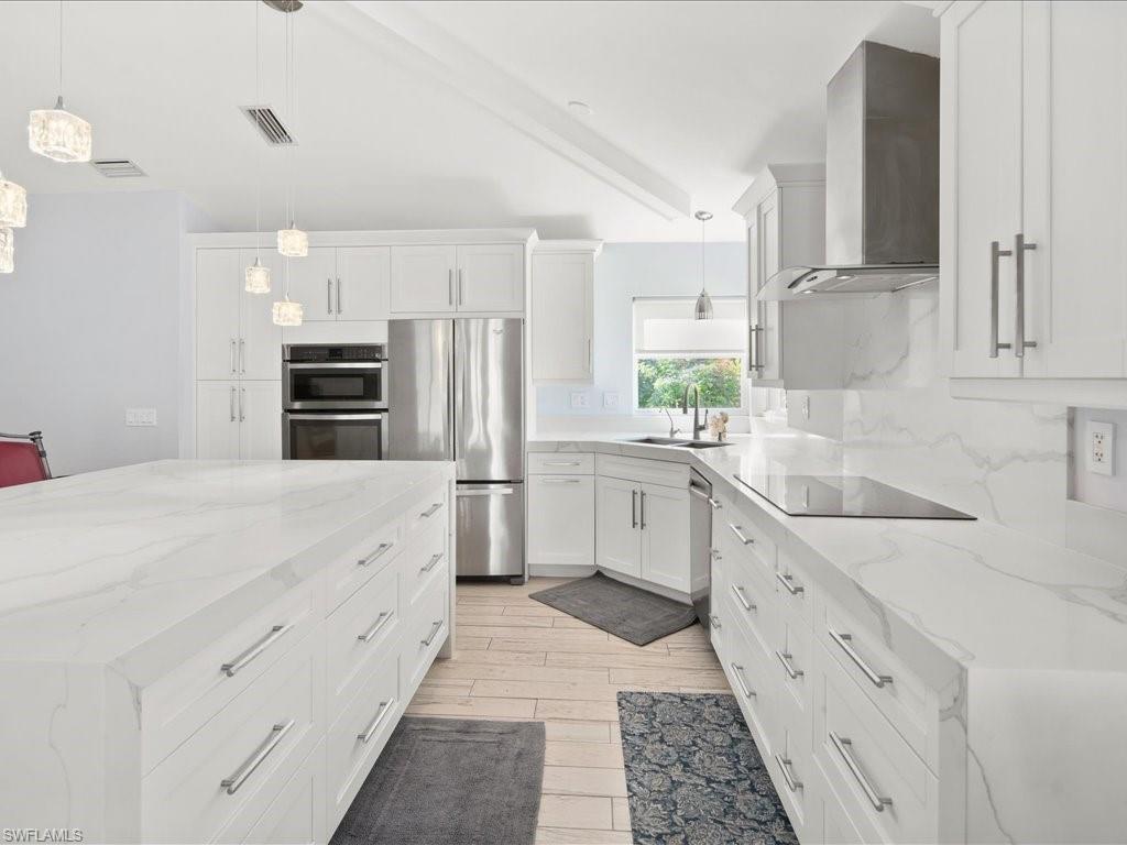 520 Soll Street Naples, FL 34109 - Photo 6 of 31 a large white kitchen with stainless steel appliances