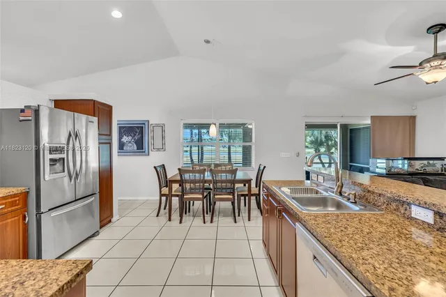 a kitchen with granite countertop a sink a counter top stainless steel appliances and cabinets