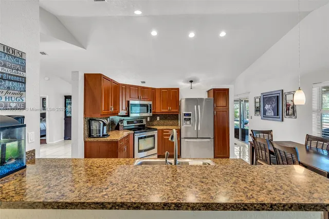 a view of a kitchen with refrigerator and dining table