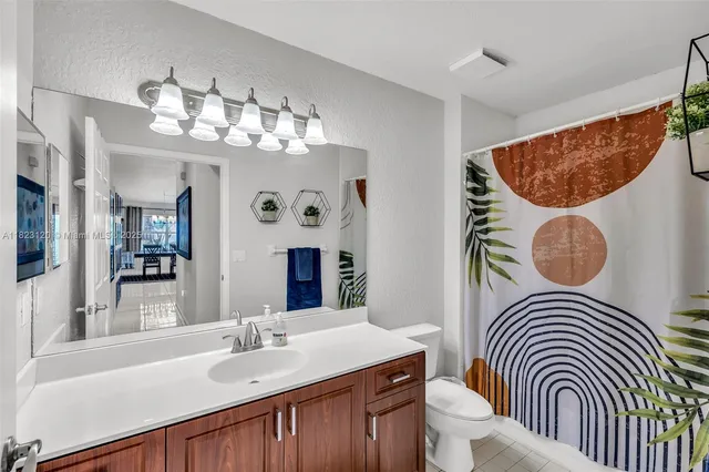 a bathroom with a sink a toilet and a mirror