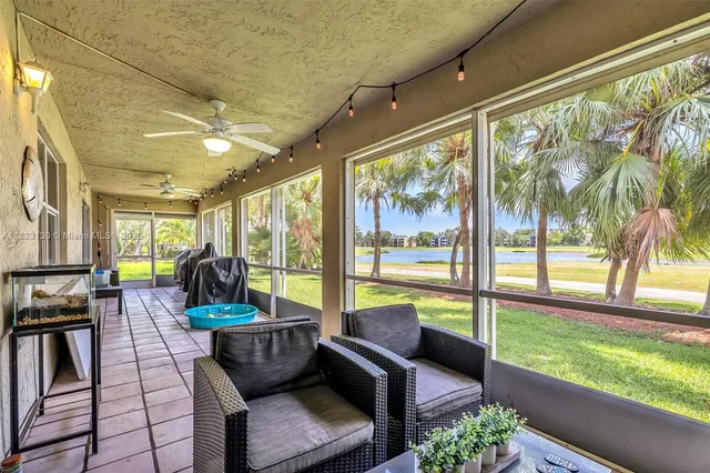 a living room with furniture and floor to ceiling windows
