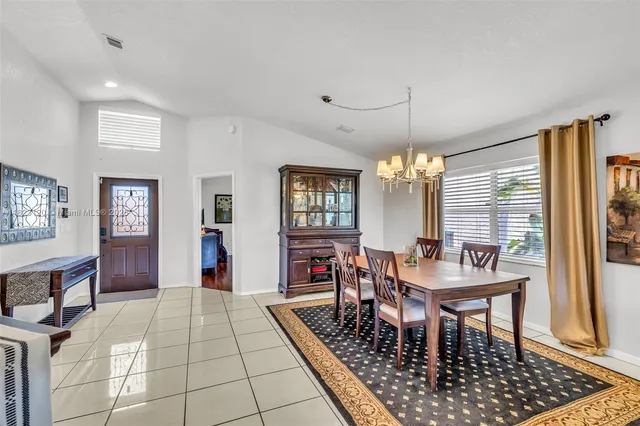 a dining room with chandelier and window