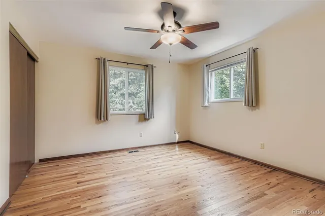 a view of a big room with chandelier fan and windows