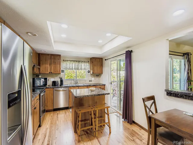 a kitchen with granite countertop a sink appliances cabinets and wooden floor