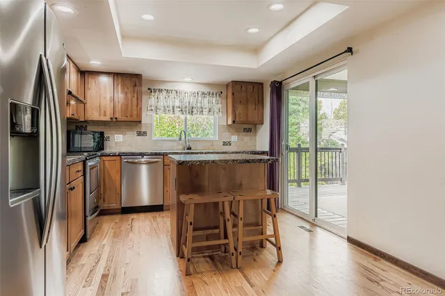 a kitchen with stainless steel appliances granite countertop a sink stove and refrigerator