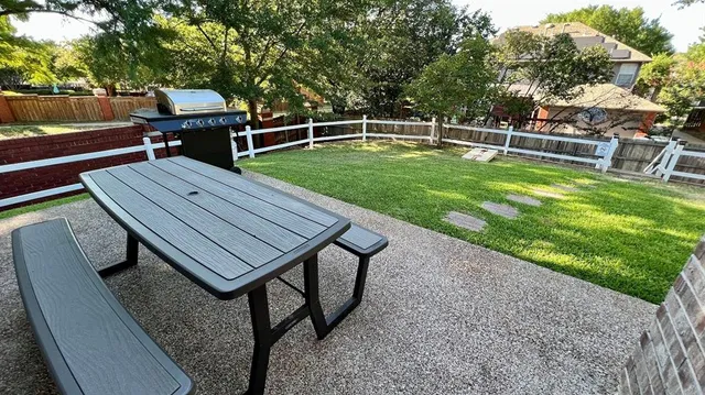 a wooden bench sitting in the middle of a backyard