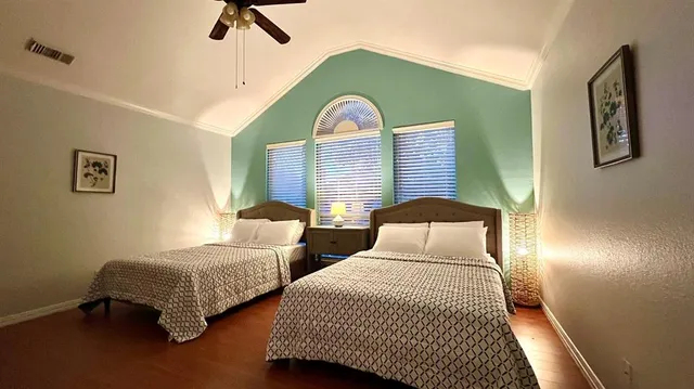 a bedroom with two beds and painting on the wall