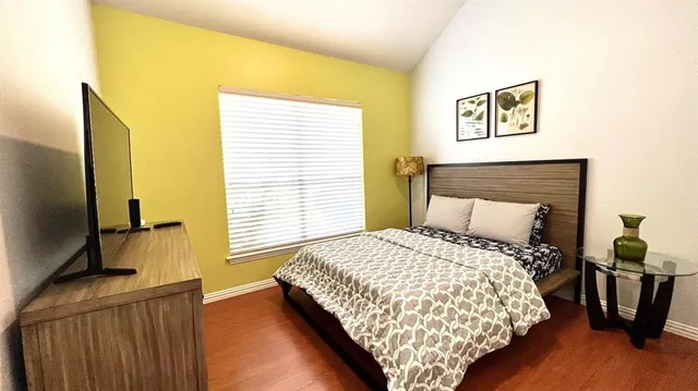 a bedroom with a bed and wooden floor