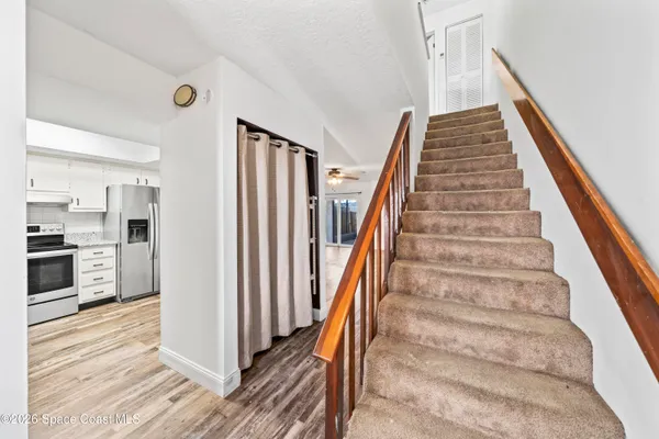 a view of a hallway with wooden floor and staircase