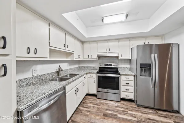 a kitchen with stainless steel appliances granite countertop a sink stove and refrigerator