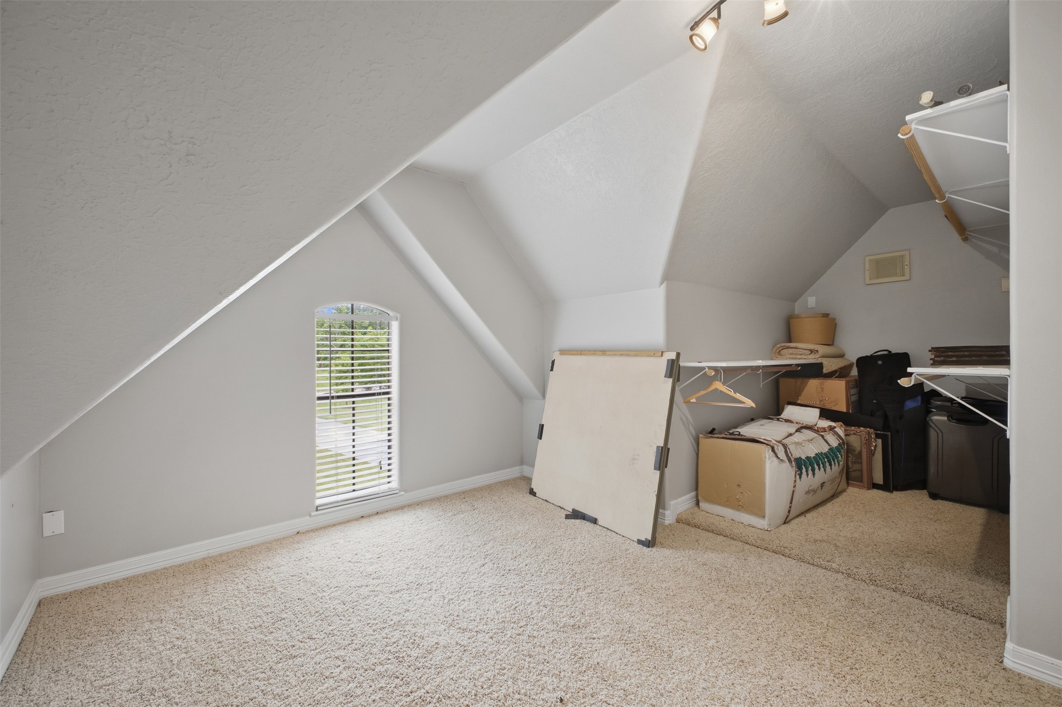 12710 Aries Loop Willis, TX 77318 - Photo 33 of 40 This attic space features sloped ceilings, carpeted floors, and a window with blinds