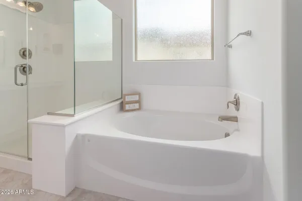 a white bath tub sitting next to a shower