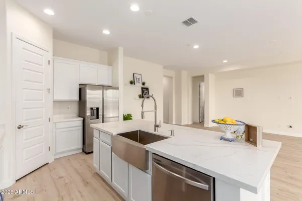 a kitchen that has a sink stainless steel appliances and view living room