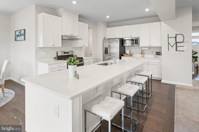 a kitchen with refrigerator and white cabinets