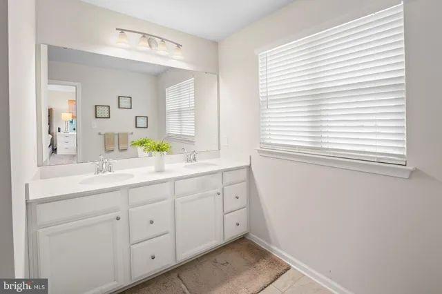 a bathroom with a sink and two mirror