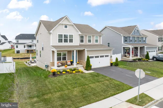 a front view of a residential houses with yard and green space
