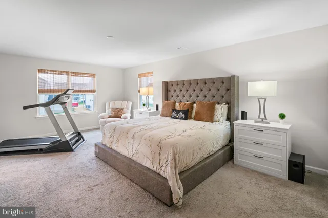 a bedroom with a bed and a flat tv screen on dresser