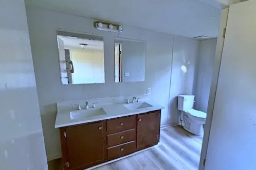 a bathroom with a toilet sink and mirror