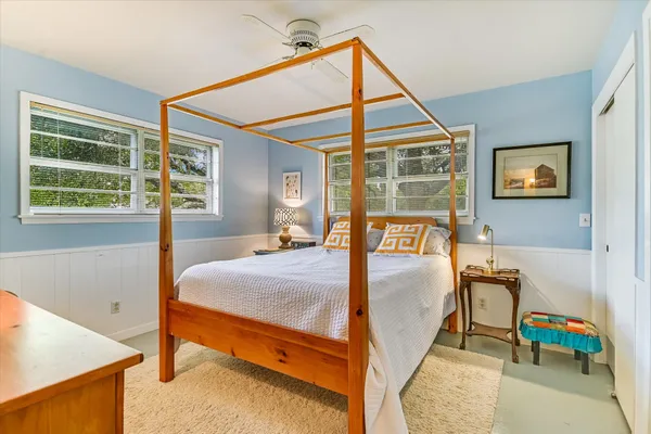a bed sitting in a bedroom next to a window