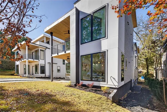 a view of a white house with a large tree in front of it