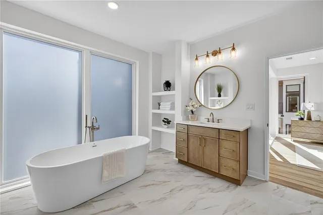 a large spacious bathroom with a tub sink and mirror