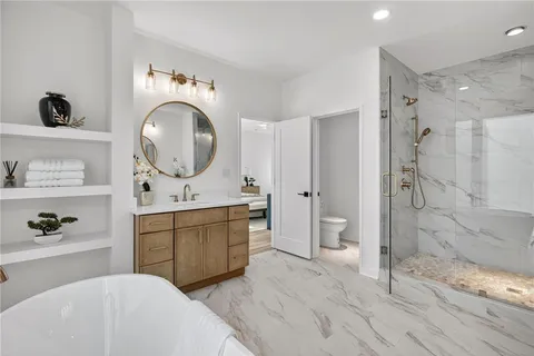 a spacious bathroom with a double vanity sink toilet mirror and shower