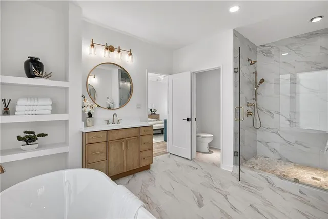a spacious bathroom with a double vanity sink toilet mirror and shower