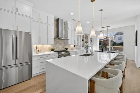 a kitchen with kitchen island a stove a refrigerator a sink and a center island