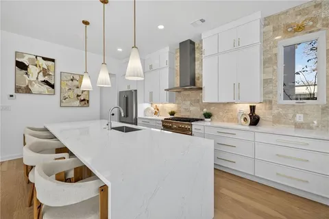 a kitchen with a sink a stove and a wooden floor