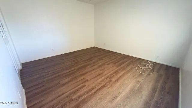 a view of a room with wooden floor and white walls
