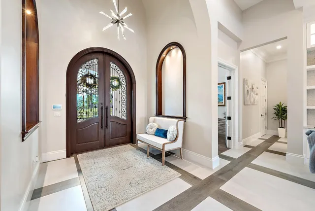 a dining room with stainless steel appliances kitchen island granite countertop a table chairs and a rug