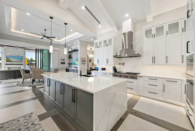 a spacious bedroom with a bed a chandelier and a window