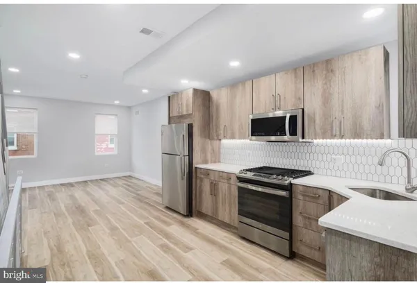 a kitchen with a sink a microwave a stove and refrigerator