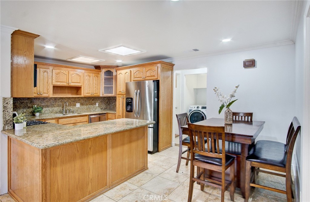 18329 Ambler Avenue Carson, CA 90746 - Photo 11 of 33 a kitchen with a dining table chairs and refrigerator