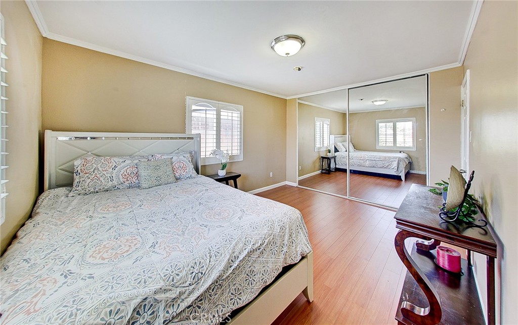 18329 Ambler Avenue Carson, CA 90746 - Photo 18 of 33 a spacious bedroom with a bed a mirror and a potted plant